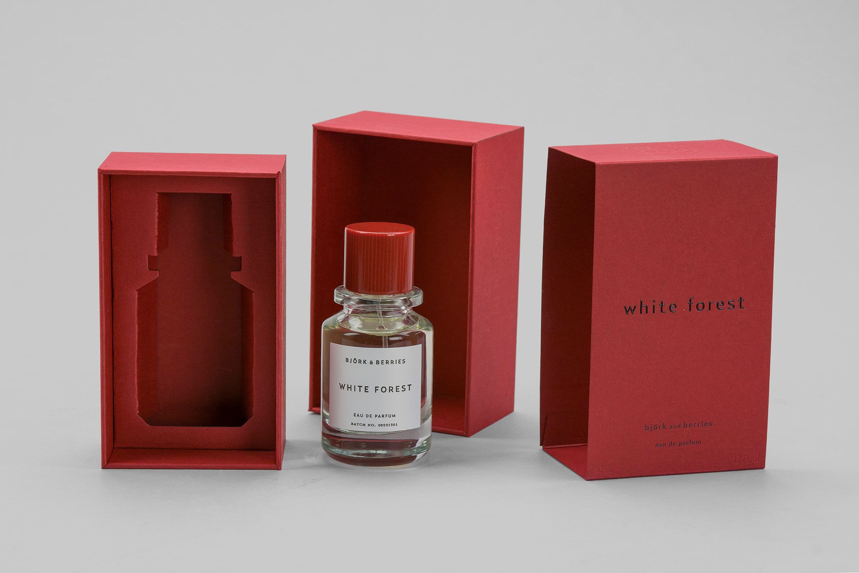 Röda rigida boxar med foliering för parfymflaskor.