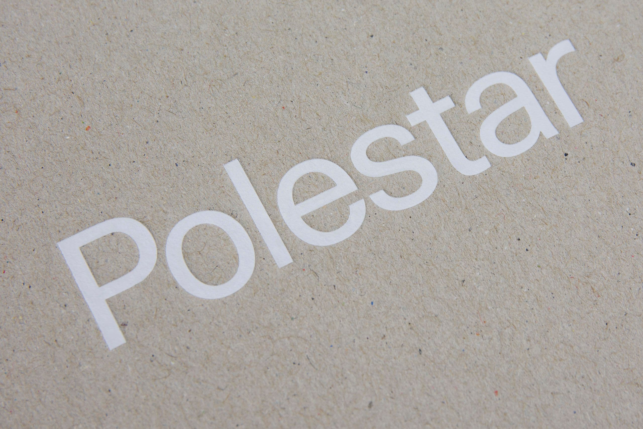 Närbild av premiumlogotryck på förpackningar i texturerat kraftpapper, som visar högkvalitativ varumärkestillämpning och hållbara trycklösningar. Bilden lyfter fram skarp vit typografi på naturlig, återvunnen kartong och demonstrerar precisionstryck, miljövänliga material och en lyxigt minimalistisk förpackningsdesign. En idealisk representation av kundanpassad branding, hållbar förpackningsproduktion och mångsidiga printtjänster för retail- och företagsvarumärken.