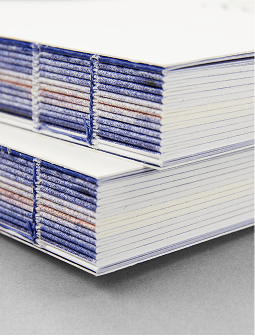 bok med öppen rygg och synlig tråd