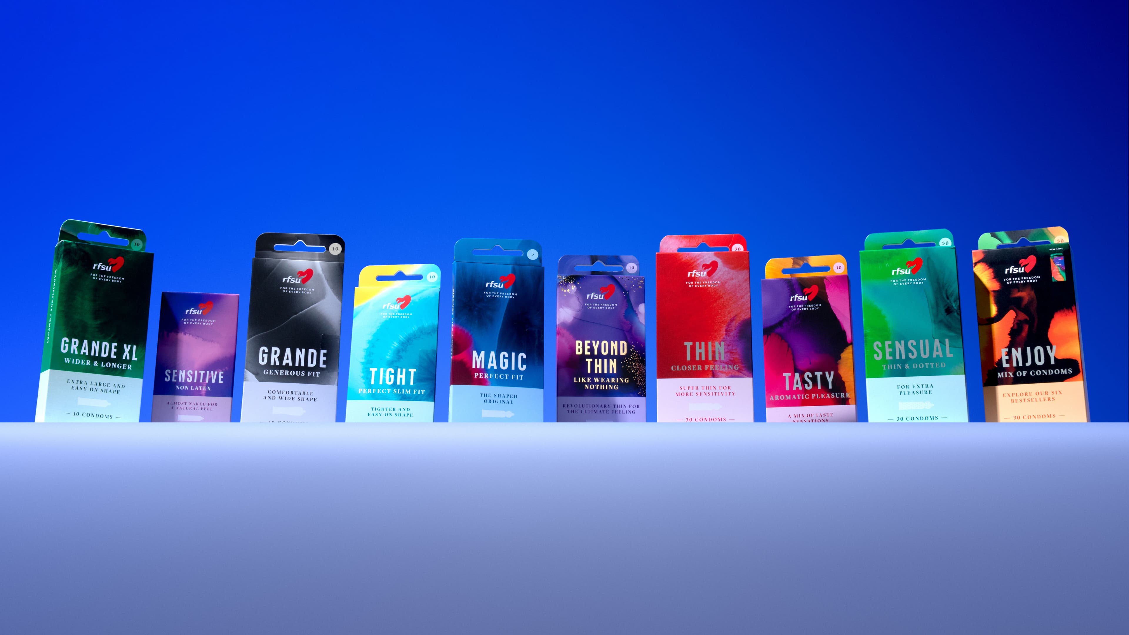 Många tryckta kondomförpackningar i olika färger på en rad.
