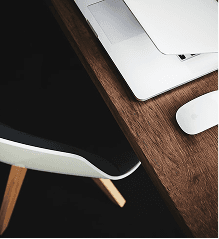 närbild på skrivbord i trä med en laptop och mus